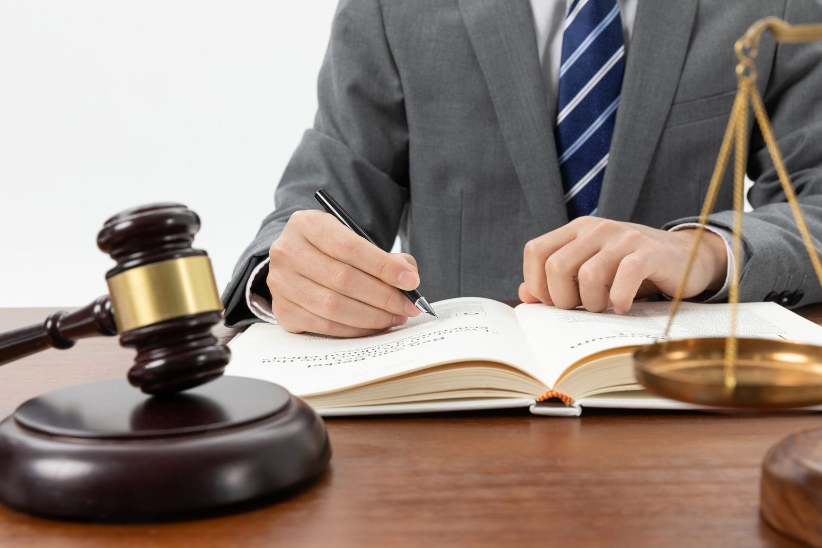 closeup-shot-person-writing-book-with-gavel-table-2-scaled-1.jpg